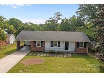 Charming single-story home featuring a cozy carport, brick accents and well-maintained landscaping at 322 S Vine St, Gastonia, NC 28052