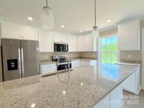 Spacious kitchen featuring stainless steel appliances and granite countertops under pendant lighting at 3650 Sentry Rd, Lancaster, SC 29720