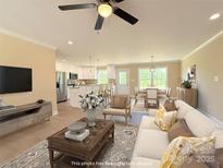Bright open-concept living room featuring a modern ceiling fan and ample natural light at 3650 Sentry Rd, Lancaster, SC 29720