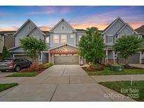 Charming townhome with stone accents, two-car garage, colorful landscaping, and a beautiful sunset at 432 Belton St, Charlotte, NC 28209