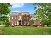 Stunning brick home boasts a lush lawn, complemented by mature landscaping and a classic architectural design at 5827 Rileys Ridge Rd, Charlotte, NC 28226