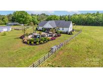 Expansive aerial view of a white home with a beautifully landscaped backyard and a fenced-in pasture at 754 Culp Ferguson Rd, Lancaster, SC 29720
