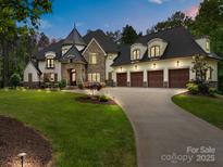 Stunning home with stone accents, a turret, three-car garage, and beautiful landscaping at 10170 Enclave Cir, Concord, NC 28027