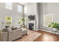 Bright living room featuring a fireplace, hardwood floors, and neutral-toned walls filled with an abundance of natural light at 111 Tilton Dr, Mooresville, NC 28115