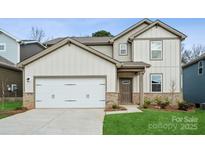 Two-story home featuring neutral siding, a two-car garage, brick accents, and a manicured lawn at 1113 Hallman Branch Ln, Lincolnton, NC 28092