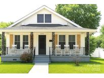 Charming home with a cozy front porch featuring rocking chairs and decorative iron railings at 169 Freeze Nw Ave, Concord, NC 28025