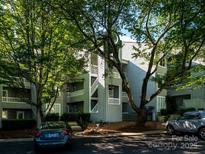 Stylish condo building with gray siding, mature trees, and well-maintained landscaping at 233 Northwest Dr, Davidson, NC 28036