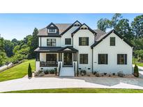 Elegant two-story home with a white brick exterior, black trim, well-manicured lawn and beautiful landscaping at 2854 Harlinsdale Dr, Rock Hill, SC 29732