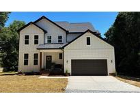 Charming two-story home featuring white siding, a dark roof, and a two-car garage at 3114 Ansonville Rd, Marshville, NC 28103