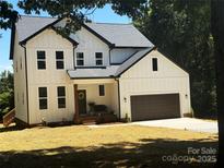 Charming two-story modern farmhouse with white siding, dark accents, and attached two car garage at 3114 Ansonville Rd, Marshville, NC 28103