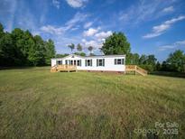 Charming single-story home featuring a welcoming wooden porch and green shutters on a spacious lawn at 317 Berry Trl, Wadesboro, NC 28170