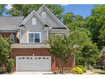 Two-story home featuring a brick facade, attached garage, and beautiful mature landscaping at 907 Ospre Ln, Fort Mill, SC 29708