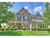 Attractive two-story brick home with lush front lawn and landscaping at 9825 Ardrey Woods Dr, Charlotte, NC 28277