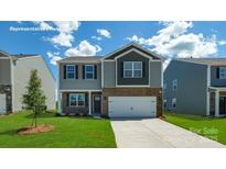 Charming two-story home featuring a two-car garage, landscaped lawn and neutral tones at 129 Way Cross Ln, Troutman, NC 28166