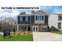 Charming two-story home with a combination of stone and siding, complimented by a well-manicured lawn at 129 Way Cross Ln, Troutman, NC 28166