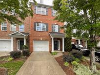 Charming brick townhome featuring a one-car garage, and well-maintained landscaping with a sidewalk leading to the front door at 1295 Amber Ridge Nw Rd, Concord, NC 28027