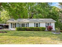 Charming single-story home with white siding, green shutters, and beautifully landscaped front yard at 130 Casper Rd, Gold Hill, NC 28071