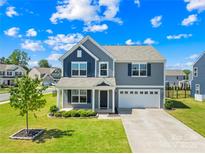 Charming two-story home with gray siding, well-manicured lawn, and attached two-car garage at 133 W Neel Ranch Rd, Mooresville, NC 28115