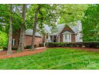 Charming brick and siding home with well-manicured lawn and lush greenery at 134 Lawrence Tee Ln, Mooresville, NC 28117