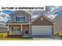 Charming two-story home featuring a covered porch, a two-car garage, and landscaped yard at 135 Way Cross Ln, Troutman, NC 28166