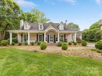 Charming single-story home featuring a welcoming front porch, manicured lawn, and mature landscaping at 2611 Forest Dr, Charlotte, NC 28211