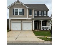 Charming two-story home featuring a two-car garage, covered porch, and well-maintained lawn at 6509 Ridgeview Commons Dr, Charlotte, NC 28269
