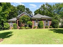 Charming brick home with well-manicured lawn, mature trees, and inviting curb appeal at 7587 Long Valley Dr, Harrisburg, NC 28075