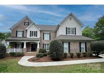 Beautiful brick two-story home with black shutters and landscaped front yard at 9624 Barnburgh Ln, Huntersville, NC 28078