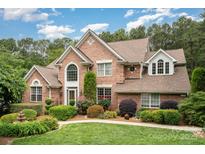Beautiful two-story brick home with manicured landscaping and a bright, sunny sky at 118 Sunrise Cir, Mooresville, NC 28117