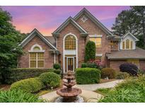 Charming brick home featuring a well-manicured lawn and inviting fountain, creating a picturesque curb appeal at 118 Sunrise Cir, Mooresville, NC 28117