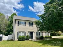Charming two-story home featuring a well-maintained lawn, black shutters, and a classic front door at 13241 Woodland Farm Dr, Charlotte, NC 28215