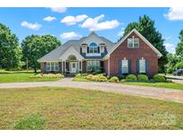 Charming brick two-story home with manicured landscaping and a curved driveway at 14340 Kendalton Meadow Dr, Mint Hill, NC 28227