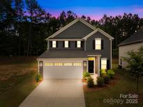 Charming two-story home with a manicured lawn, attached two-car garage, and welcoming curb appeal at 2012 Slippery Rock Ln, Monroe, NC 28112
