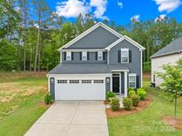 Charming two-story home featuring a two-car garage, landscaped yard, and classic architectural details at 2012 Slippery Rock Ln, Monroe, NC 28112