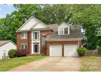 Beautiful brick home with two-car garage and well-maintained landscaping, including a large front lawn and mature trees at 2608 Yarrow Rd, Charlotte, NC 28213