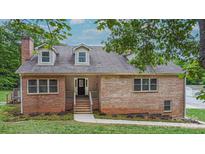 Charming brick home featuring dormer windows, well-maintained landscaping, and inviting front porch at 332 E Rebound Rd, Lancaster, SC 29720