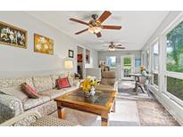 Bright and cozy living room featuring ceiling fans, neutral walls and flooring leading to a sunroom at 3690 Birchwood Ln, Denver, NC 28037