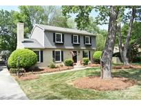Charming two-story home with gray and brick exterior, manicured lawn, and mature trees at 3918 Rea Rd, Charlotte, NC 28226