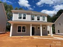 Charming two-story home with a welcoming front porch and classic architectural details, bathed in beautiful daylight at 4021 Grommet Ct, Matthews, NC 28105