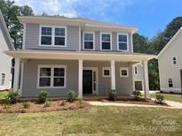 Charming two-story home featuring a welcoming front porch with classic columns and fresh landscaping at 4021 Grommet Ct, Matthews, NC 28105