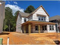 New home exterior featuring a covered porch, visible framework, and a bright, open design at 4029 Grommet Ct, Matthews, NC 28105