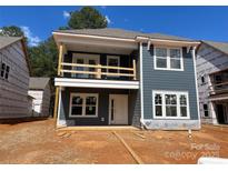 Two-story home featuring blue siding, a white trimmed balcony, and an unfinished front yard at 4033 Grommet Ct, Matthews, NC 28105