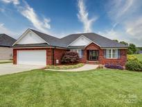 Charming brick home featuring a well-manicured lawn, front-facing garage, and inviting walkway at 4618 Dallas High Shoals Hwy, Dallas, NC 28034