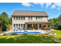 Lovely backyard featuring a private pool, outdoor seating, and covered patio area at 5105 Paisano Ln, Waxhaw, NC 28173