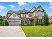 Charming two-story home with stone accents, three-car garage and well-manicured lawn at 5105 Paisano Ln, Waxhaw, NC 28173