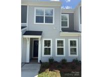 Charming two-story home with classic siding, multiple windows, and a cozy front porch at 5817 Tuckaseegee Rd, Charlotte, NC 28208
