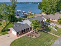 Charming brick home boasts lakeside living with docks, pool and lush green lawns at 8005 Island View Ct, Denver, NC 28037