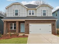 Charming two-story home featuring a brick facade, a two-car garage, and a light blue front door at 110 Obadiah Ct, Mooresville, NC 28115