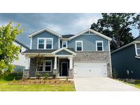 Charming two-story home featuring stone accents, a welcoming front porch, and a well-manicured lawn at 113 Obadiah Ct, Mooresville, NC 28115