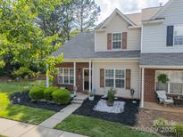 Charming townhome with a brick facade, tasteful landscaping and a sidewalk leading to the front door at 11515 Retriever Way, Charlotte, NC 28269